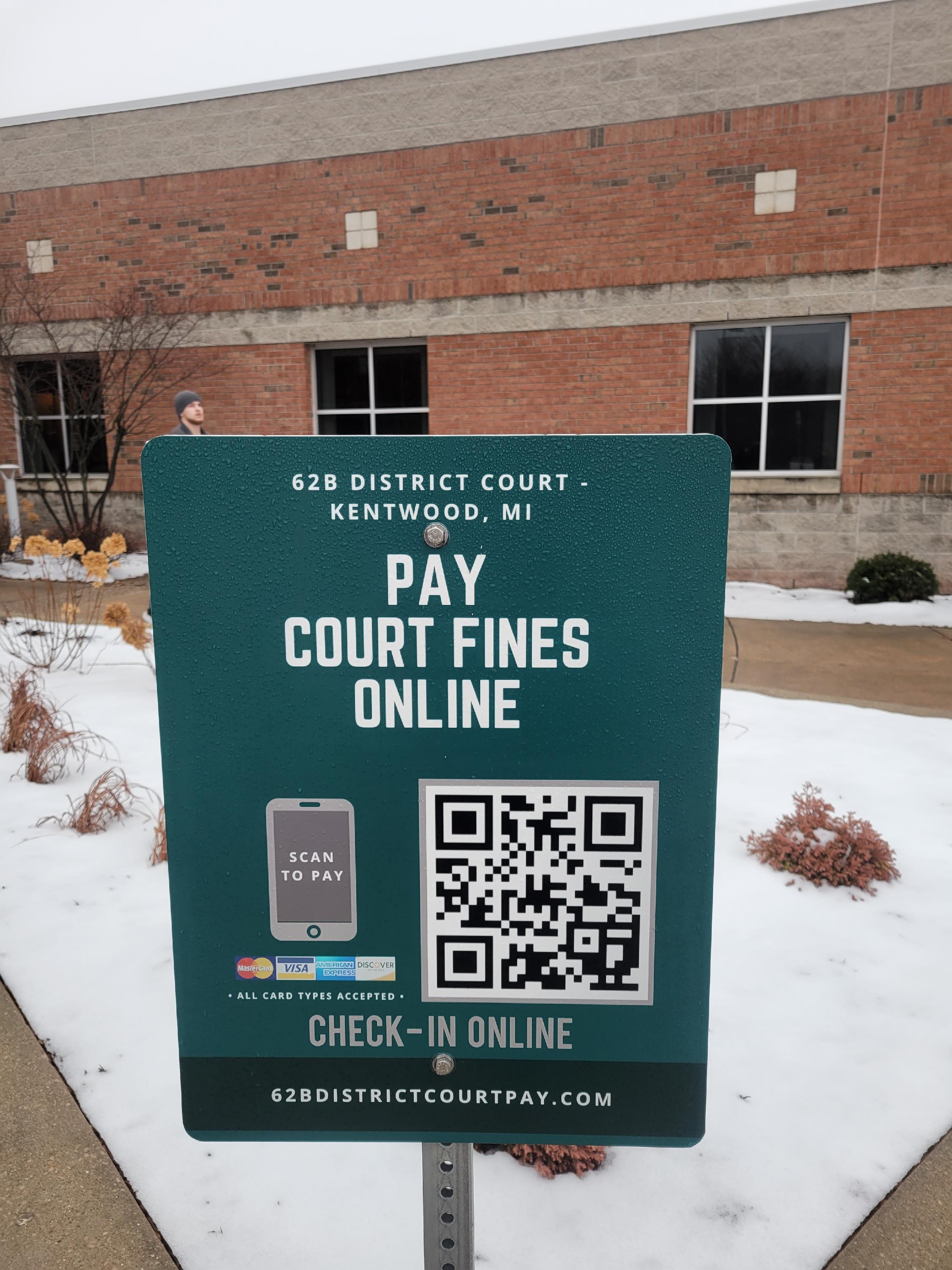 Signage in front of the Kentwood Justice Center featuring the QR code used to pay court fines online